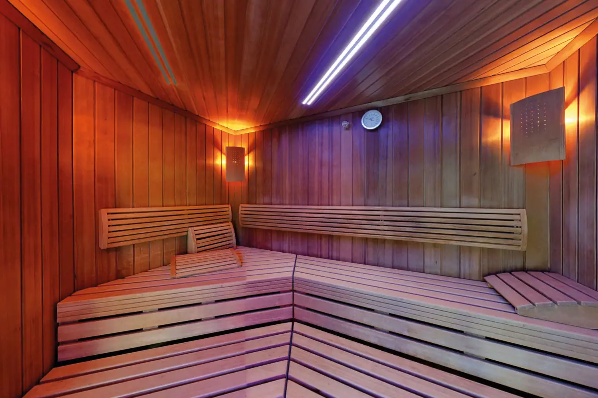 Sauna in legno con luce blu e viola.