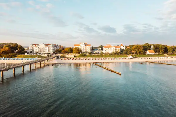 A-ROSA Ostseehotel Kühlungsborn Ein Gewässer mit einem Steg und Gebäuden im Hintergrund.
