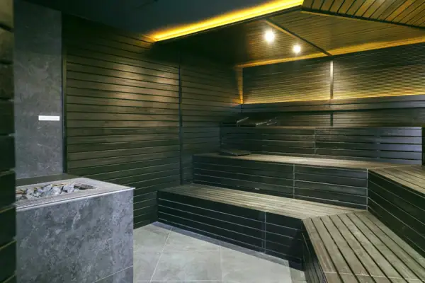 Sauna con lavandino e fontana, interno con pareti piastrellate.