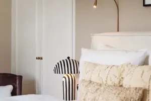 Un letto con cuscini e una lampada.