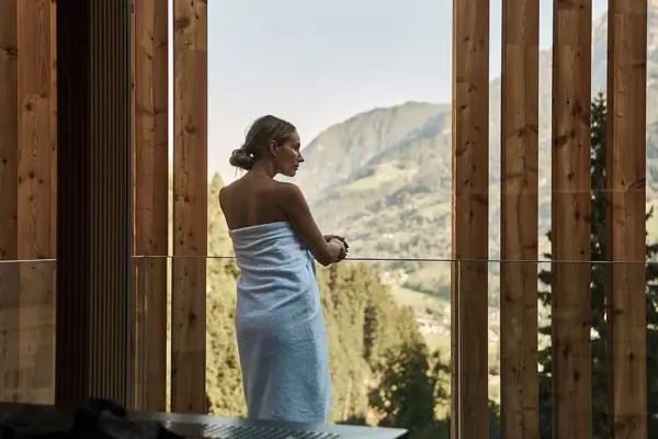 Una donna con un asciugamano sta alla finestra.