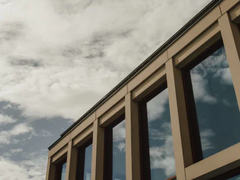 Edificio con molte finestre sotto un cielo nuvoloso.