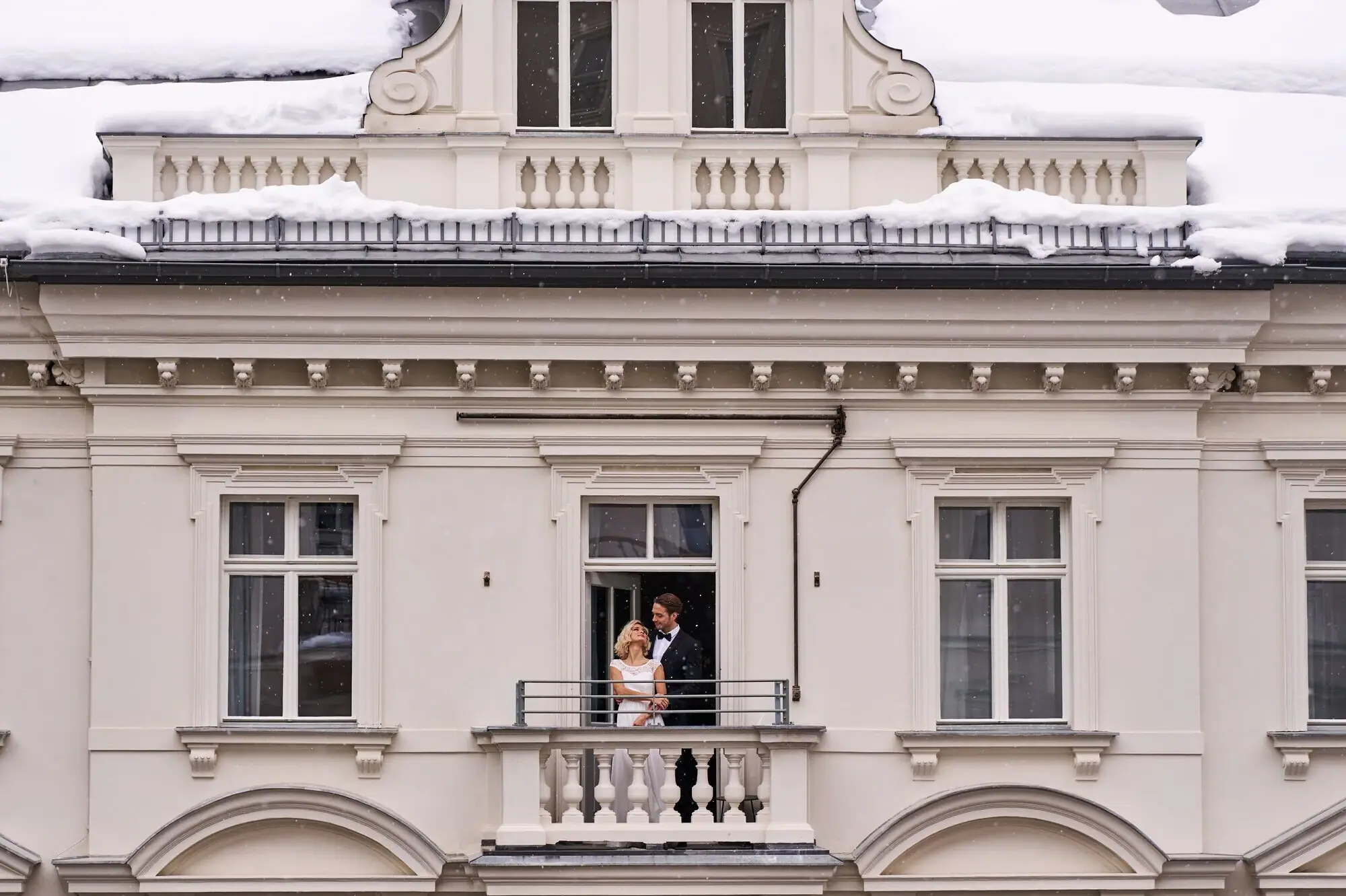 Un uomo e una donna in piedi su un balcone davanti a un edificio.