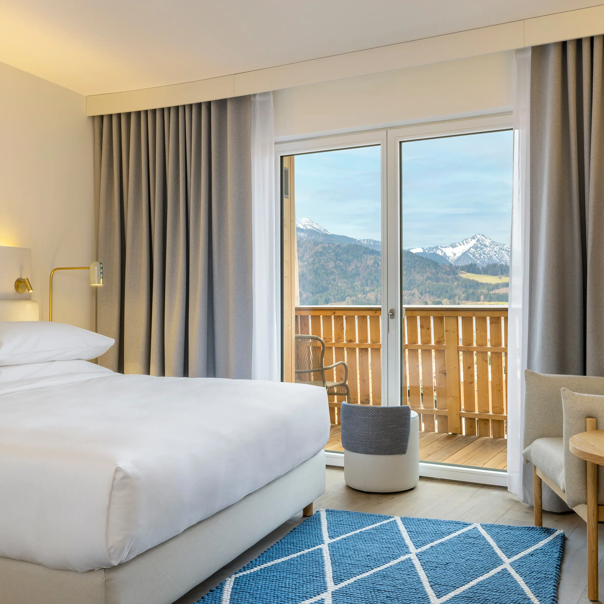 Una camera d'albergo all'A-ROSA Tegernsee con un letto, un divano e un tavolino.