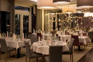 Capodanno a Sylt all’A-ROSA Una sala dell'hotel A-ROSA con tavoli e sedie, allestita per la notte di Capodanno a Sylt.