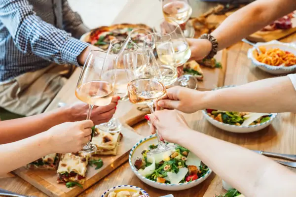 Un gruppo di persone che tiene bicchieri di vino.