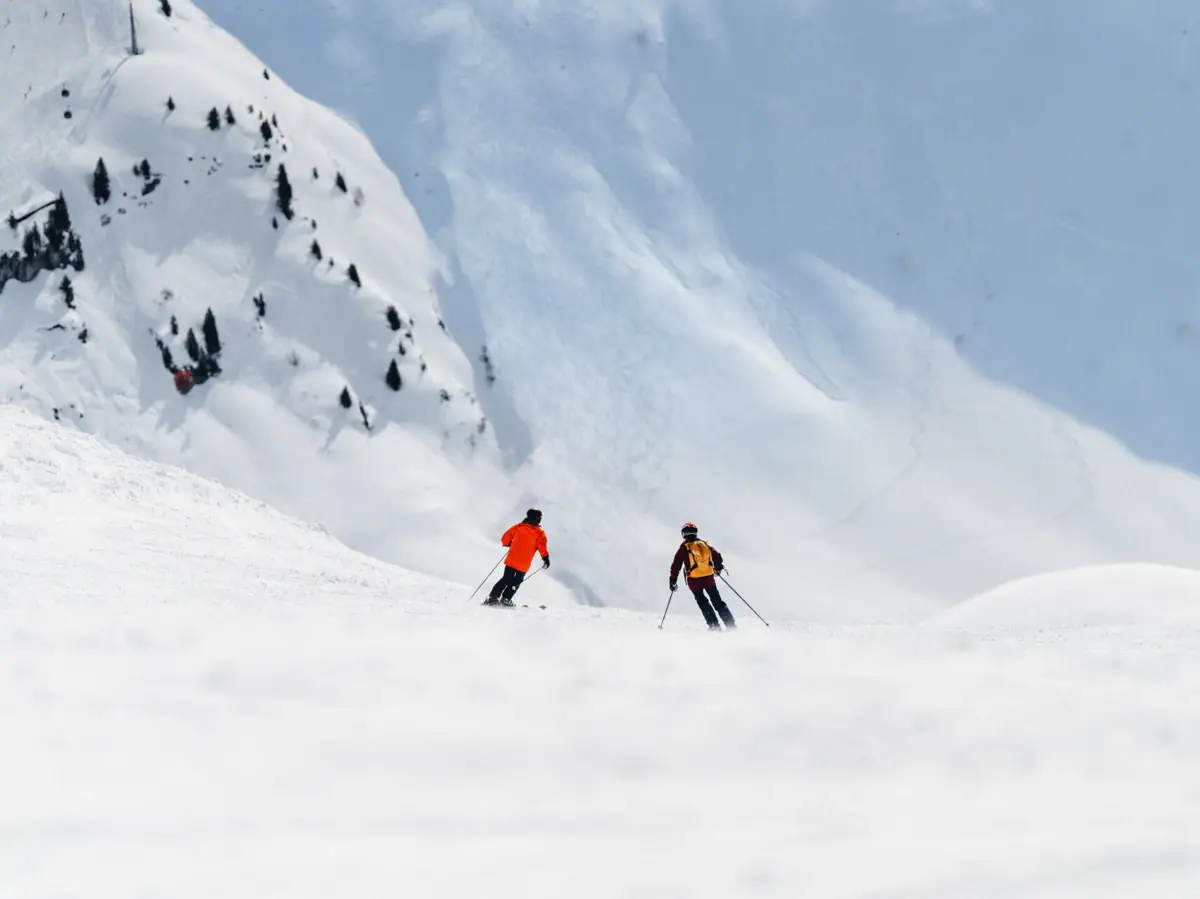 Un gruppo di persone scende con gli sci lungo una montagna innevata.