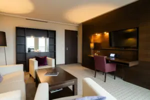 Una camera d'albergo con televisione e tavolo.