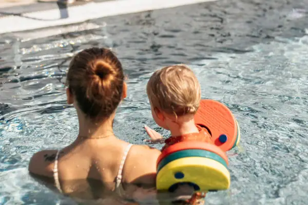 Eine Frau und ein Kleinkind im Schwimmbecken.