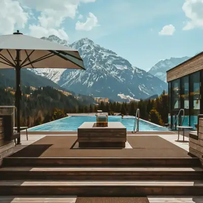 Ein Outdoor Infinity Pool mit Holzdeck und großem Sonnenschirm vor einer schneebedeckten Bergkulisse im Hintergrund.