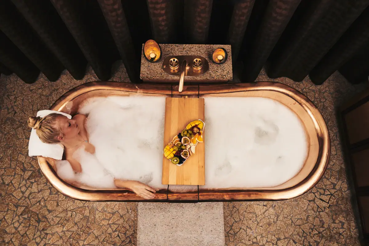 Una donna in una vasca da bagno con schiuma.