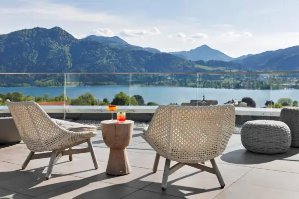 Un tavolo e delle sedie su una terrazza affacciata su un lago.