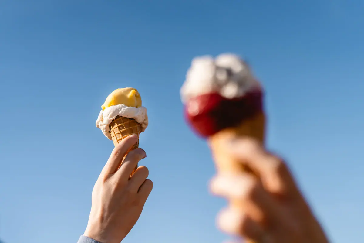 Due mani reggono due coni gelato.
