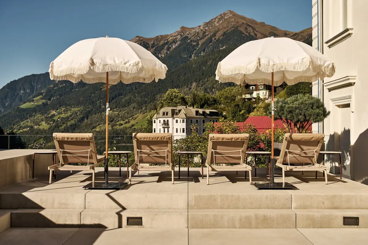 Un gruppo di sedie e ombrelloni su una terrazza.