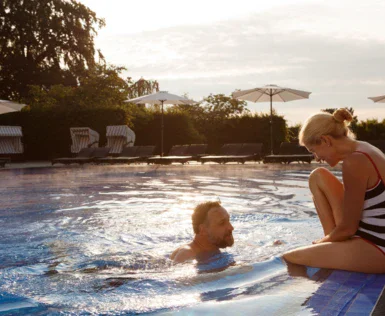 Uomo e donna in una piscina all'aperto.