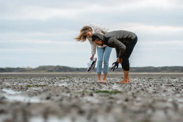 Un uomo e una donna in piedi in un campo fangoso.