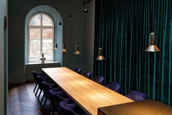 Una stanza con un lungo tavolo e sedie.