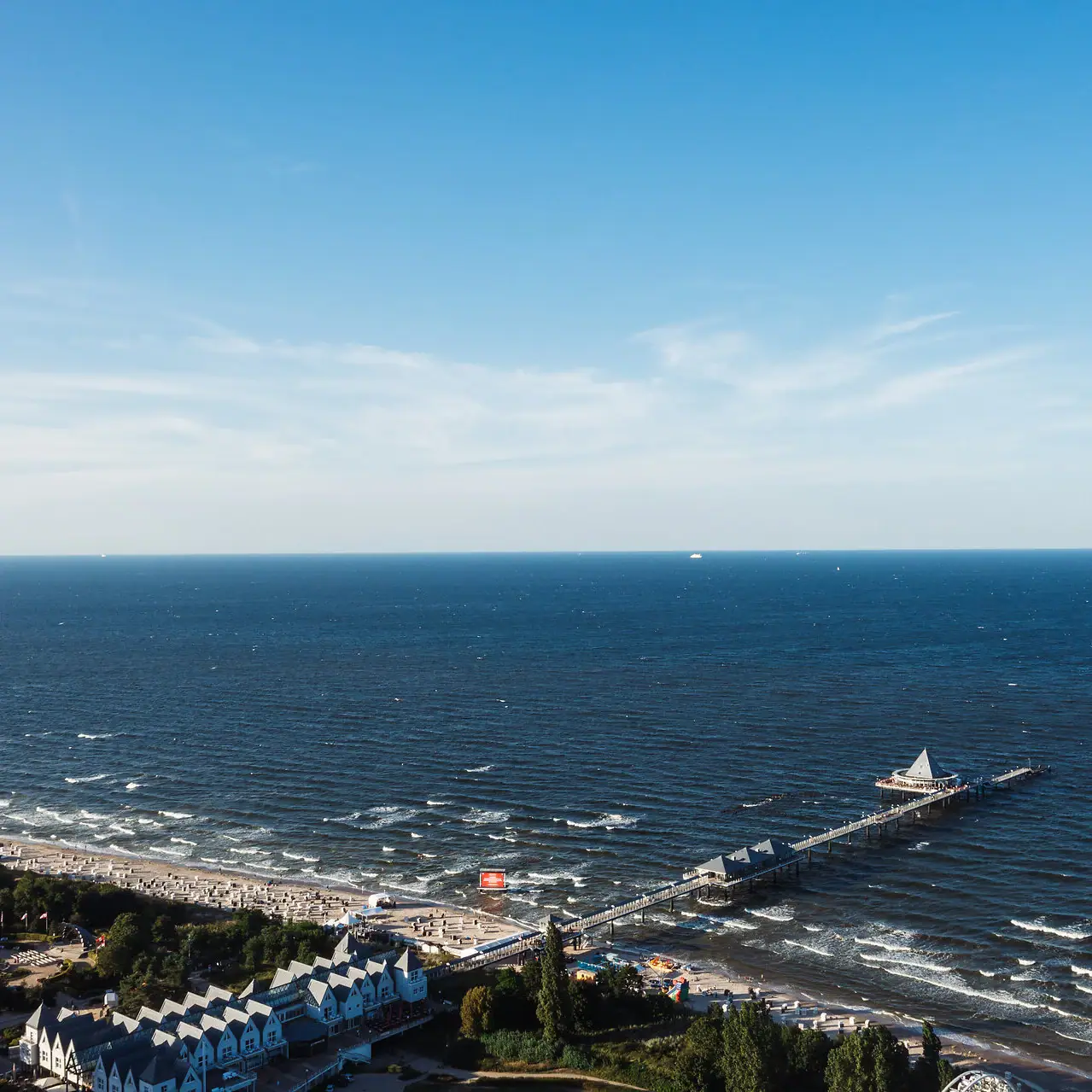 Heringsdorf Molo sull'acqua con cielo sereno e nuvole sparse.
