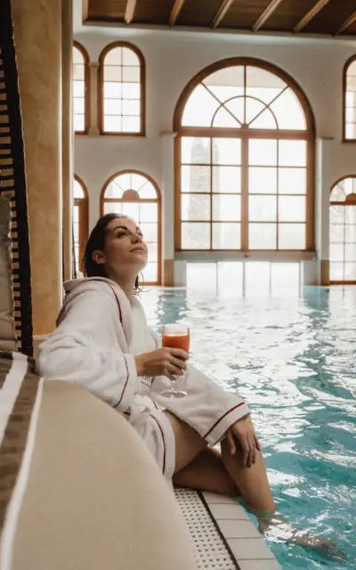 Donna sorridente in abito da sposa seduta in una sauna.