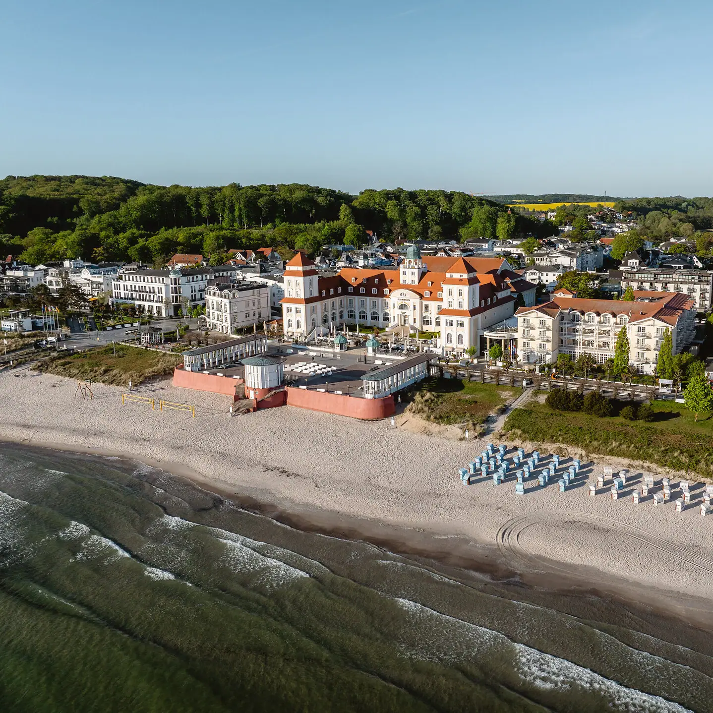 Kurhaus Binz Spiaggia con un grande edificio e sedie.