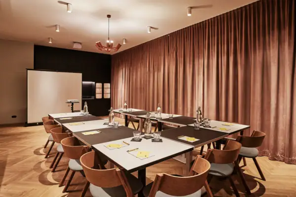 Ein Tagungsraum mit einem großen Tisch und Stühlen.