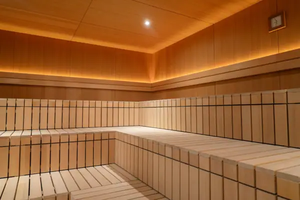 Panca di legno in una stanza con pareti e soffitto visibili.