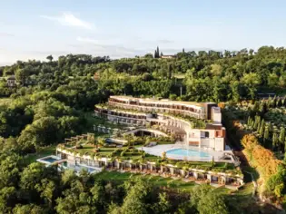 Edificio con piscina circondato da alberi e da un paesaggio verde.