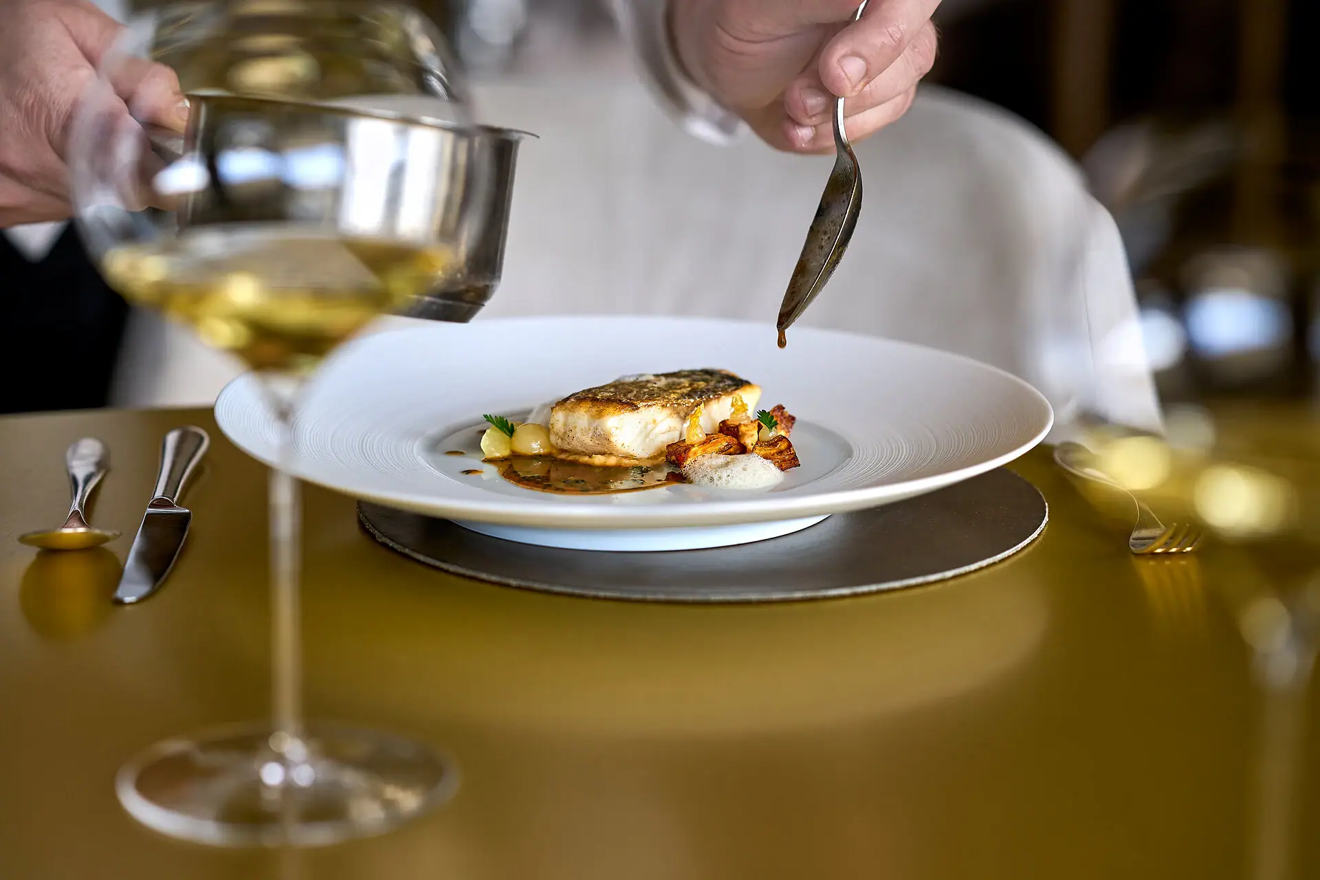 Kilian Stuba Persona che tiene un cucchiaio sopra il cibo su un piatto.