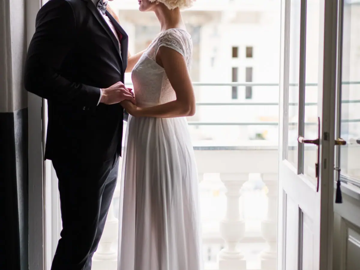 Una donna in abito da sposa bianco accanto a un uomo.