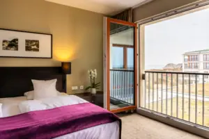 Camera da letto con accesso al balcone aperto e letto elegante.