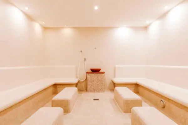 Ein Raum mit Bänken und einer Dusche.