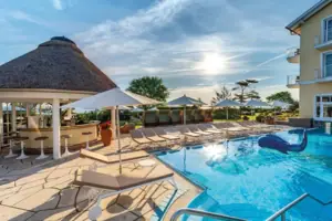 Una piscina con lettini e ombrelloni.