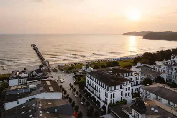 Spiaggia con edifici e un molo sullo sfondo.
