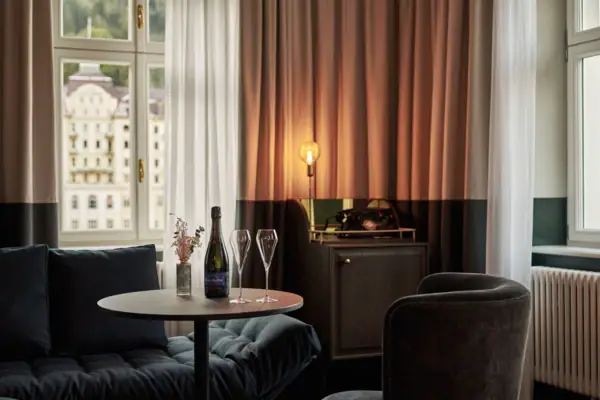 Un tavolo con bicchieri da vino e una lampada davanti a una finestra.