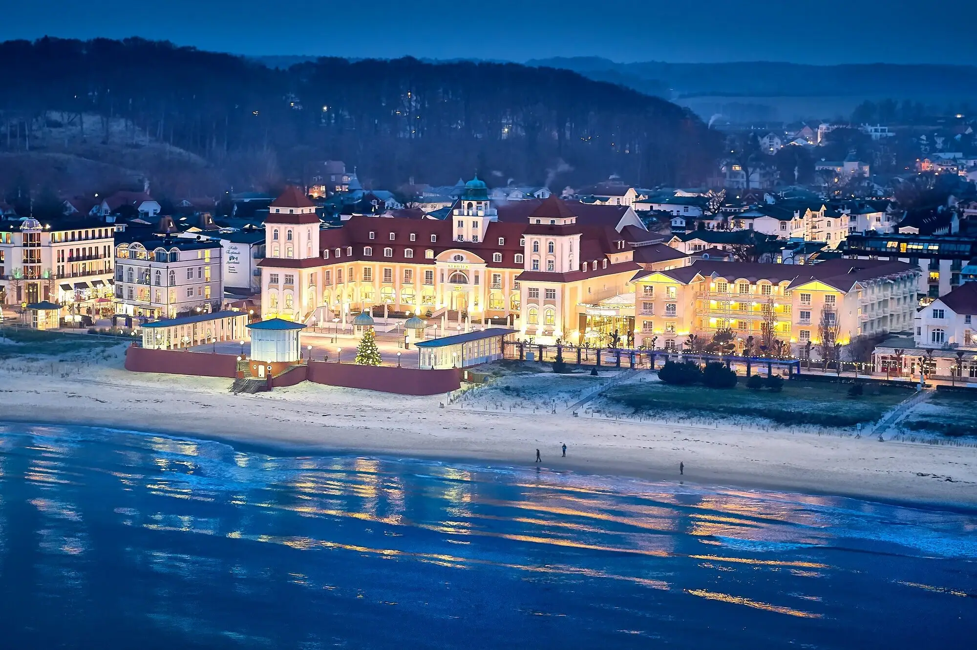 Kurhaus Binz Edificio grande illuminato su una spiaggia.