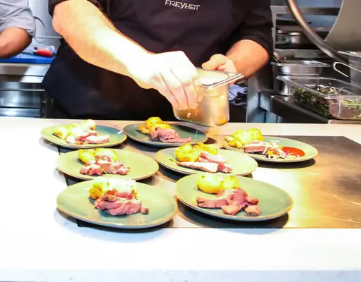 Due uomini in cucina mentre preparano da mangiare.