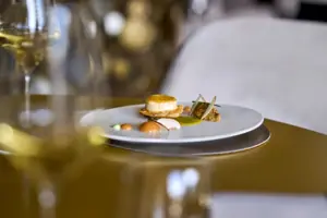 Ristorante Un piatto con del cibo su un tavolo, accanto a un bicchiere da vino.