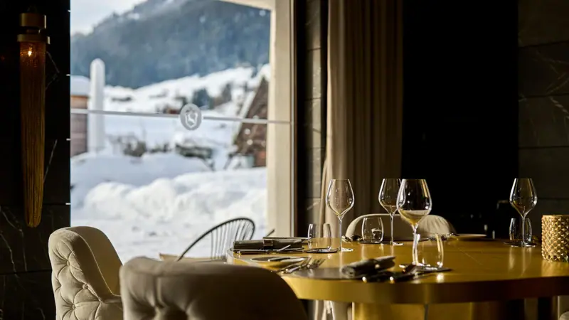 Ristorante Un tavolo con bicchieri da vino e sedie davanti a una finestra.