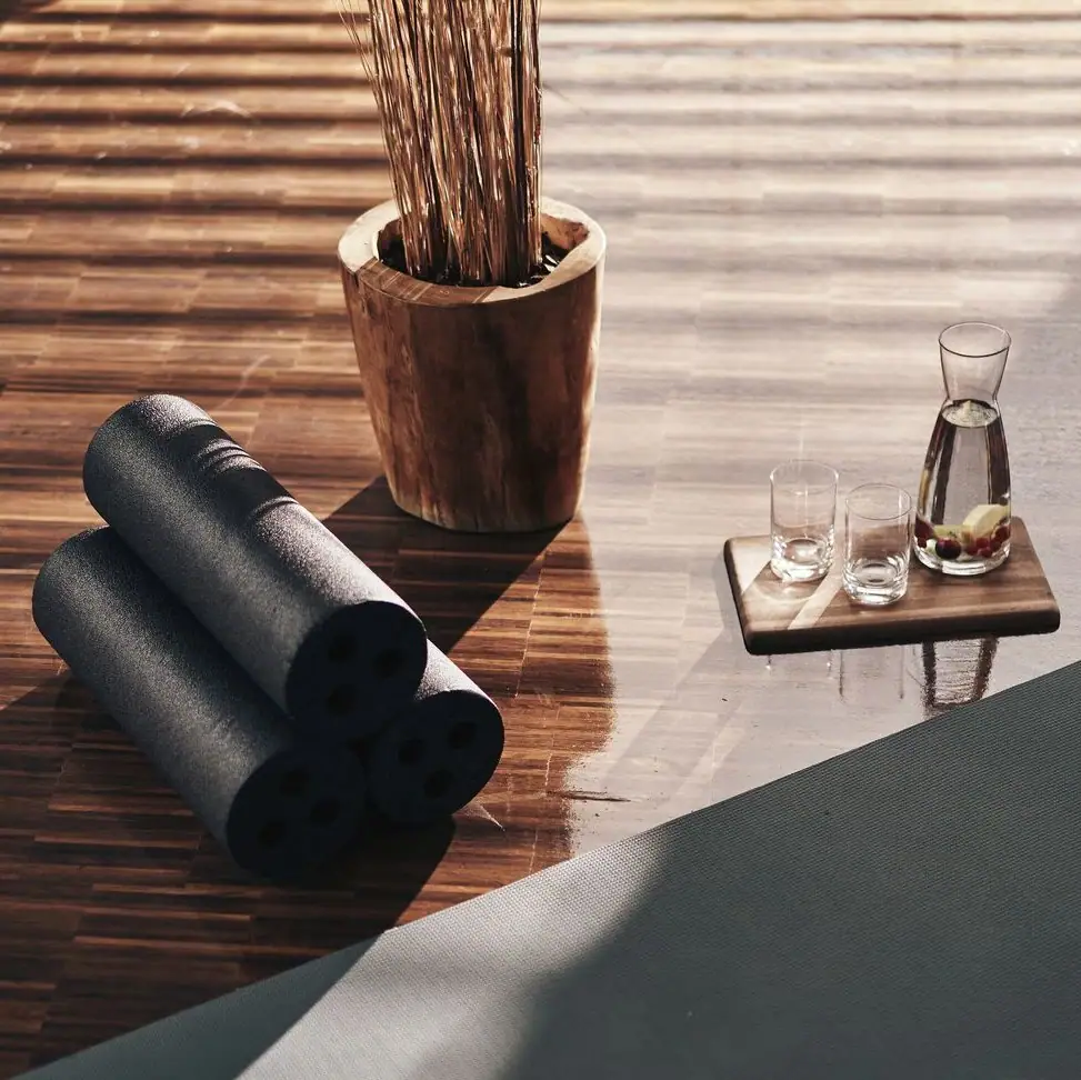 Yogamatten und Gläser auf einem Holzboden