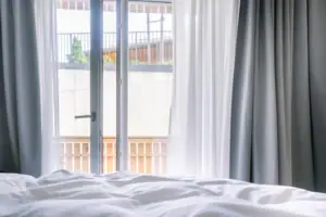 Prospettiva: visibilità limitata Un letto con lenzuola bianche e tende.