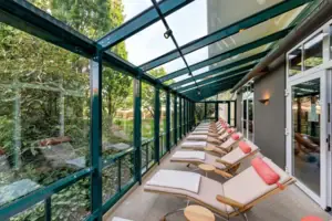 Una fila di sedie a sdraio in una stanza con pareti di vetro.