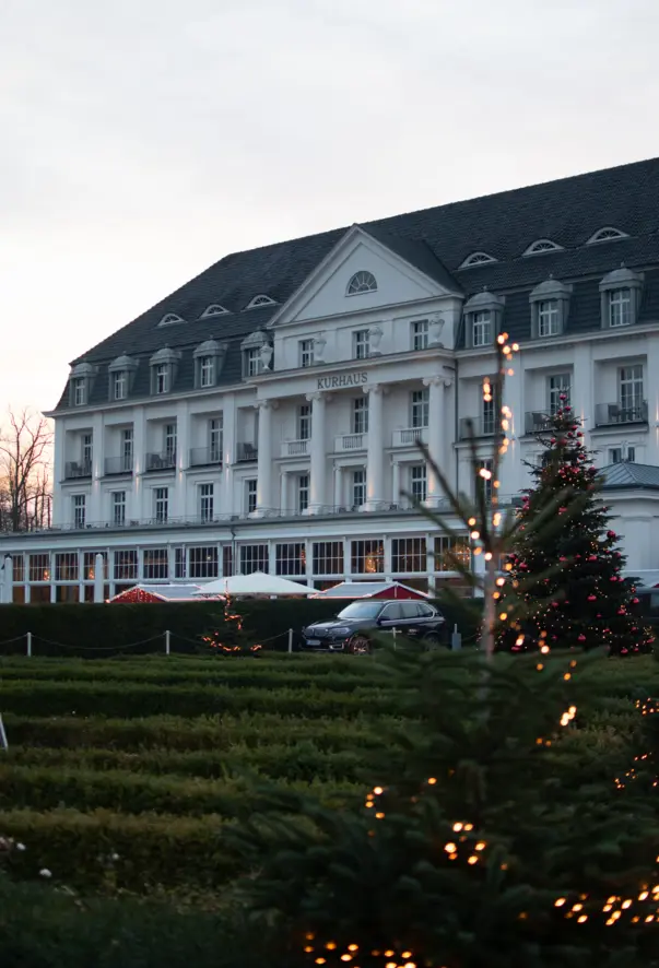 Grande edificio bianco con un albero di Natale davanti.