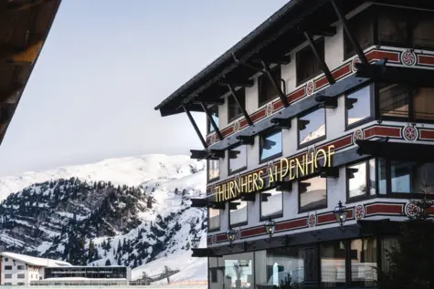 Un edificio con un'insegna sul lato, circondato da neve e montagne.