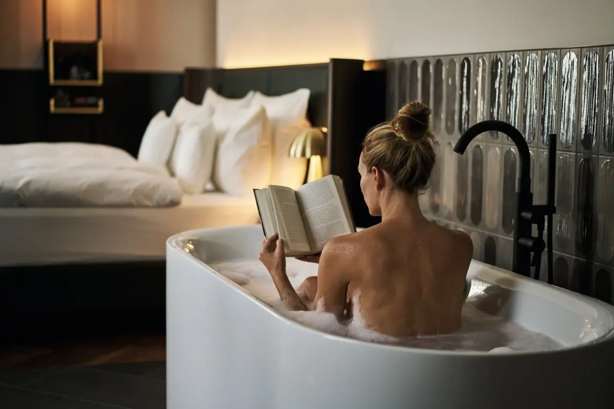 Una donna nella vasca da bagno legge un libro all’A-ROSA Bad Gastein.