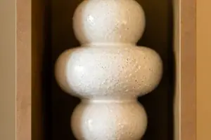 Vaso bianco su una mensola di legno.