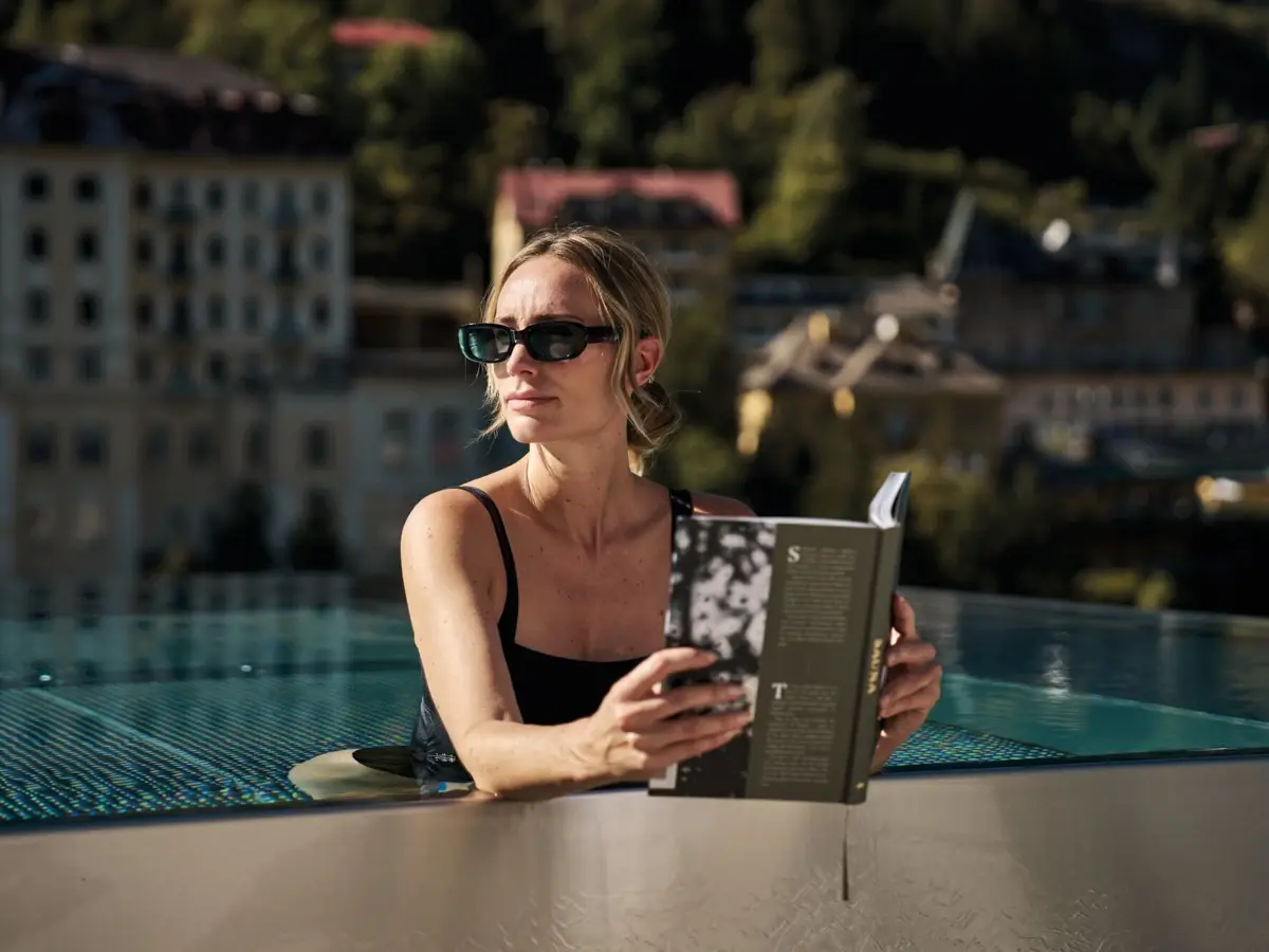 Pooltime Eine Frau liest ein Buch im Aussenpool