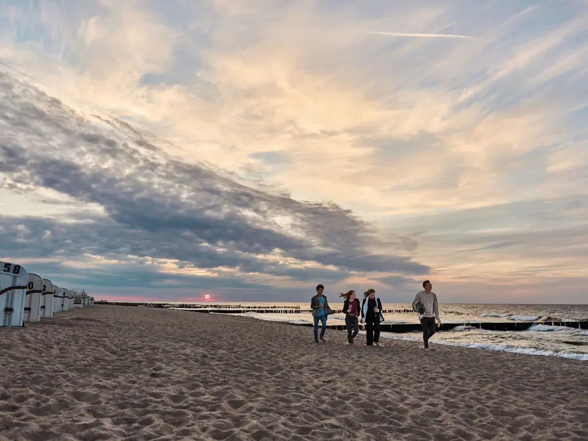 Un gruppo di persone che cammina su una spiaggia.