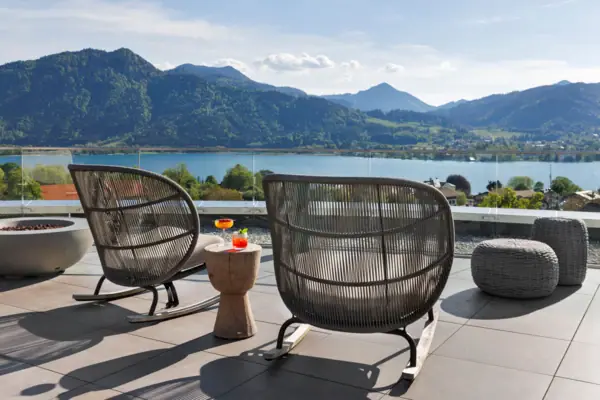 Una sedia e un tavolo sulla terrazza panoramica del NI BAR con vista sul lago.