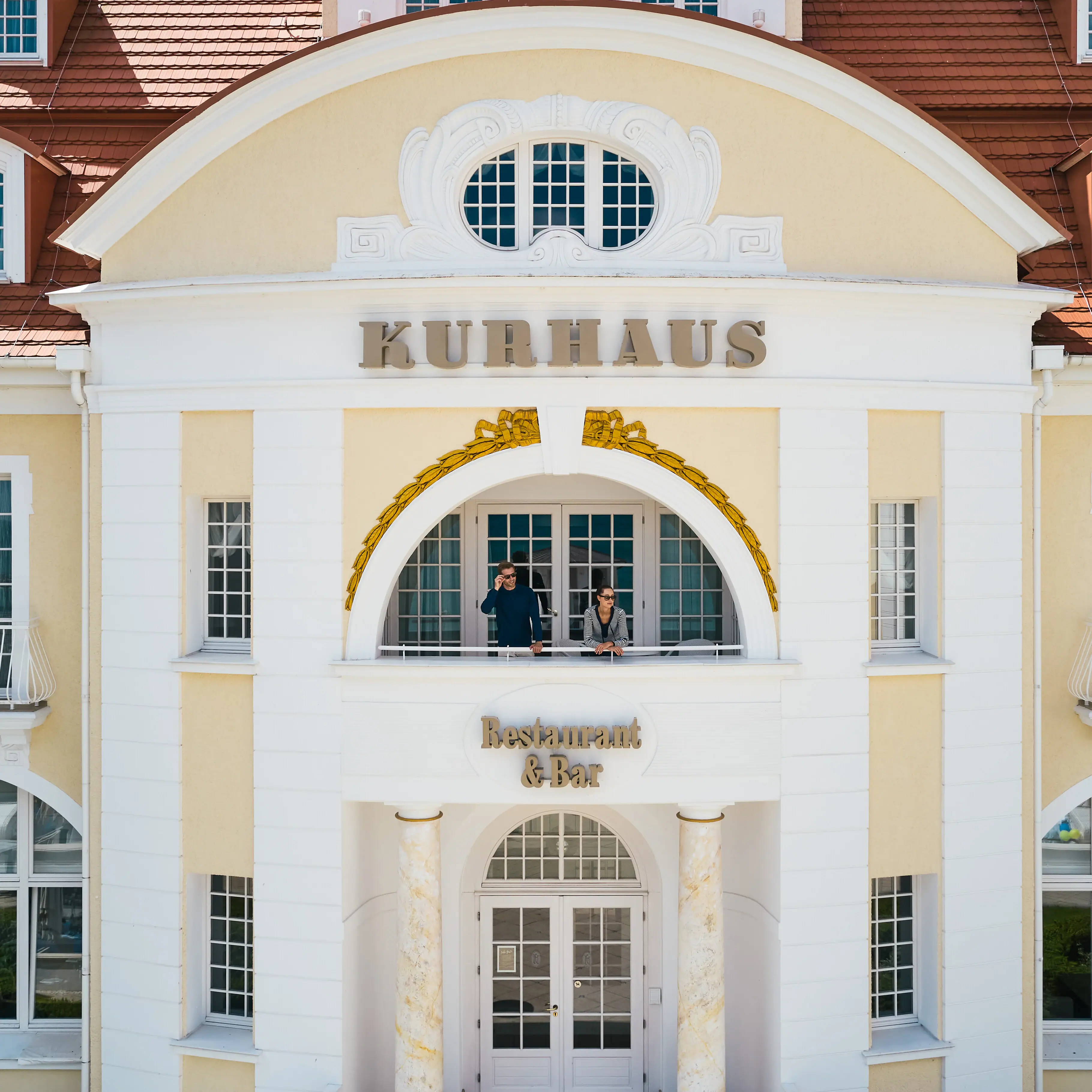 Ein Gebäude mit einem Paar, das auf dem Balkon steht.
