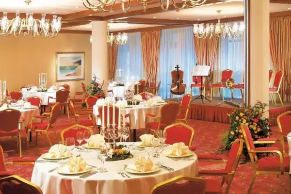 Ein Raum mit Tischen und Stühlen, dekoriert mit Tischdecken und Tischdekorationen.